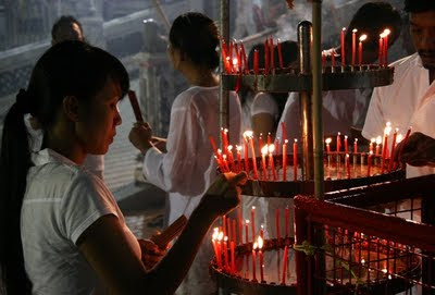 Lighting candles outside the shrine