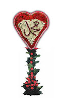 Üzerinde Arapça Hz. Muhammed yazan güllerden yapılmış kalp şekilli çelenk.