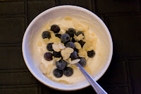 Frozen bluenerries and flaked almonds over greek yogurt with vanilla whey