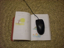 Anaîs utilise une souris d'ordi sur un carnet de notes