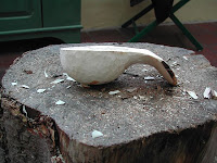 using a knife and axe to carve a spoon
