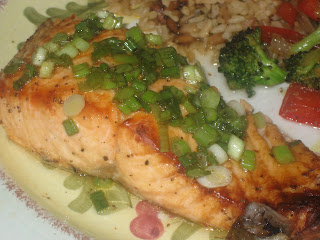 plate of grilled salmon covered in green onions