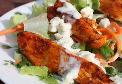 plate of lettuce and shredded carrots with buffalo chicken and blue cheese dressing