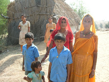 Rajasthani desert family in front of grass hut