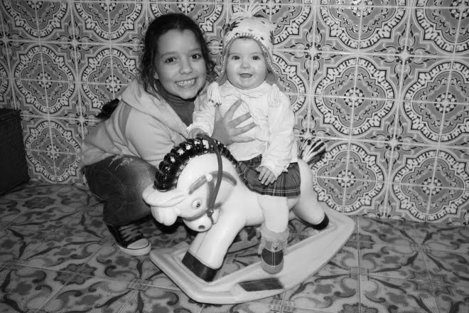 Crianças no cavalo de plastico