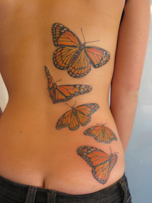 five monarch butterflies at lower back tattoo
