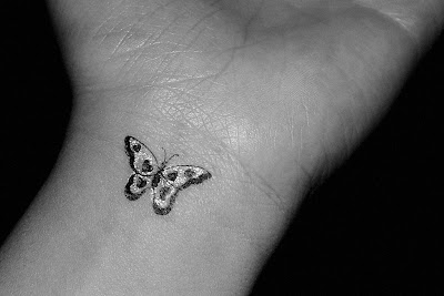 Little butterfly tattoo in the left arm