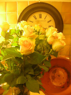 yellow roses in from of a clock