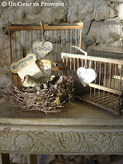 On a flowery side table, old cages and bird nest