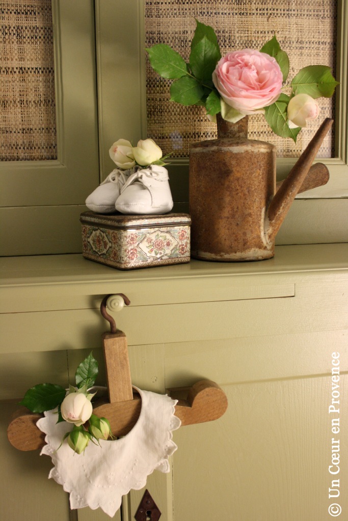 On a child’s old wooden hanger, a small embroidered, nicely scalloped bib