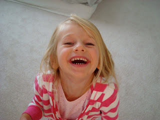 Young girl looking up at camera with big smile