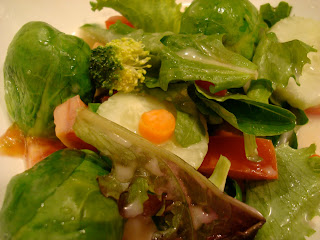 Mixed Greens with vegetables on white plate