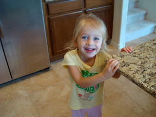 Smiling young girl holding onto countertop