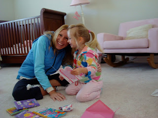 Young girl and woman sitting on floor reading a card