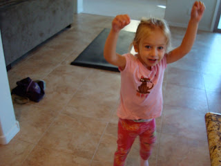Young Girl wearing pink standing with arms above head 