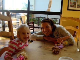 Woman and young girl at table playing with toys