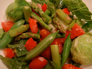 Green salad in white bowl topped with dressing