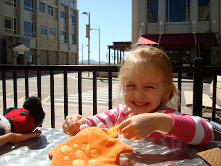 Young child sitting at outdoor table playing with toys