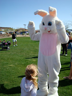 Young girl facing Easter Bunny watching him