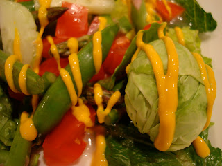 Close up of salad drizzled with mustard
