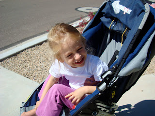 Young girl in stroller squinting with sun in her eyes
