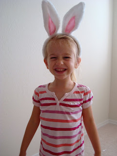Young girl in stripped shirt wearing easter bunny ears