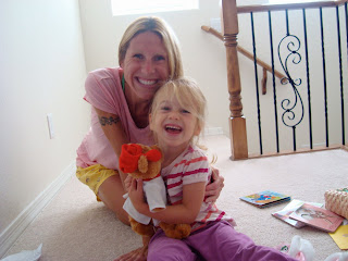 Woman and young girl hugging while holding stuffed animal