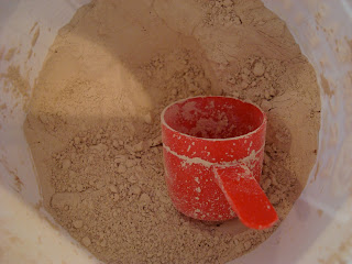 Inside un Warrior Brown Rice Protein Powder in Chocolate with red scoop