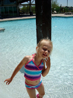 Young girl in bathing suit playing in pool