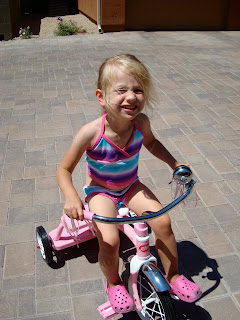 Young girl on tricycle smiling