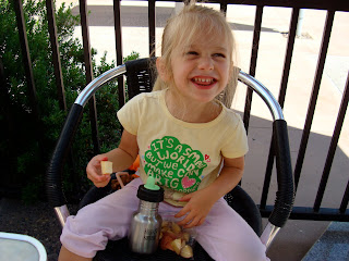 Young girl eating fruit in chair smiling