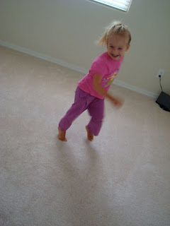 Little girl running around room smiling