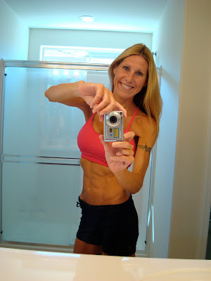 Woman in workout clothes showing off toned abs
