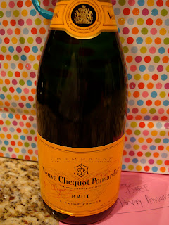 Champagne bottle in front of gift bag