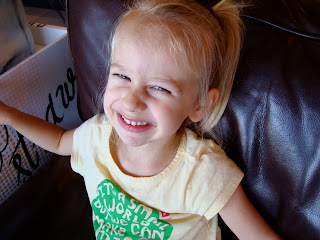 Young girl reaching across chair and smiling