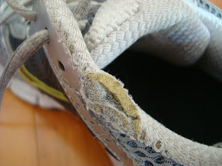 Side top of sneaker showing tear from running