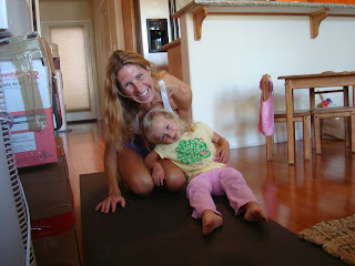 Woman and little girl smiling on yoga mat