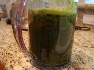 Greens juice in measuring cup after being juiced
