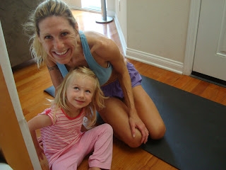 Woman and child on yoga mat smiling