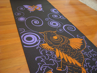 Black purple and orange yoga mat on wooden floor - 3