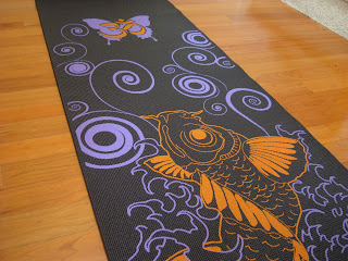 Black purple and orange yoga mat on wooden floor