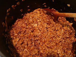 In process of making homemade granola in pan with spoon stirring