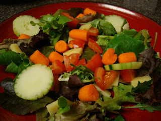 Greens with mixed vegetables on red plate