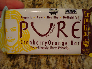 Hand Holding Pure Cranberry Orange Bar