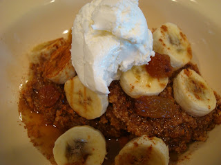Raw Vegan Apple Carrot (Pan)Cakes on plate topped with sliced bananas, maple syrup, raisins, cinnamon and whipped cream
