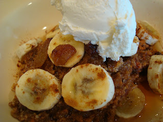 Close up of Raw Vegan Apple Carrot (Pan)Cakes on plate topped with sliced bananas, maple syrup, raisins, cinnamon and whipped cream