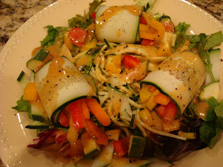Raw Cucumber Wraps over greens and diced vegetables on white plate - 11