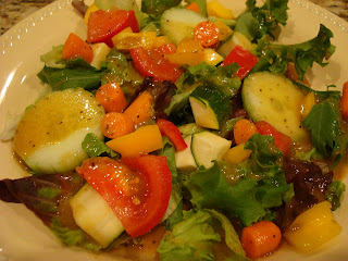 Mixed greens and vegetables in white shallow bowl