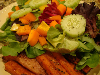 Mixed vegetable salad served with sweet potato fries on white plate