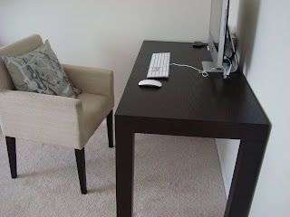 Black dest with tan chair and computer on desk